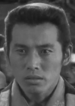 A photo of a young Japanese man in feudal-era clothes looking anxiously at something just off-camera