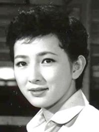 A young Japanese woman with short hair in modern clothes, looking into the camera
