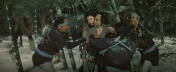 A Japanese man and a woman in a snowy landscape cling to each other while armed police try to pry them apart