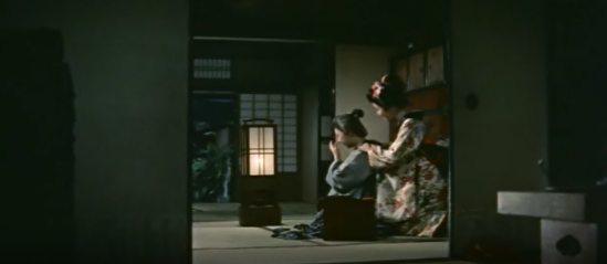 Image of a merchant's dwelling in 18th Century Japan, with a young woman in traditional clothing massaging an older woman's neck