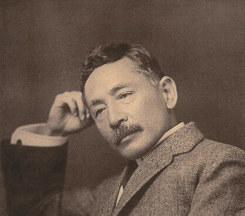 Portrait of a middle-aged Japanese man in a Western suit reclining his head against his hand: the author Natsume Soseki