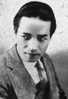 A publicity photo of a young Japanese man in a suit