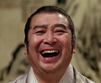 Close-up photo of a Japanese man in feudal costume, facing the camera and laughing