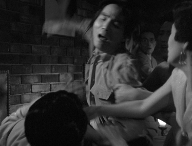 An enraged Japanese man in modern clothes is shown beating another man, as a young woman at right attempts to intervene