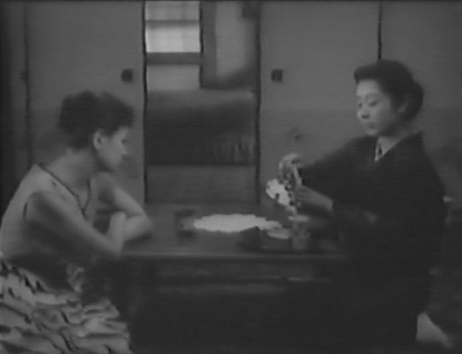 A photo of two Japanese women sitting in an interior space, one wearing modern dress and the other wearing a kimono