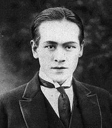 Publicity photo of Japanese actor Shima Koji, wearing a jacket and tie and looking into the camera