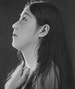A young Japanese woman looking up, her hands just below her neck