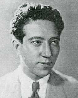 Photo of a young Japanese man in a Western suit and tie, looking slightly to one side of the camera