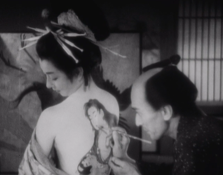 A screenshot from a film showing a Japanese painter of the feudal period painting a picture upon a woman's naked back as if it were a canvas