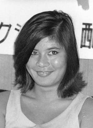 Headshot portrait of a smiling Japanese woman in modern clothes, with a hairdo popular in the 1960s