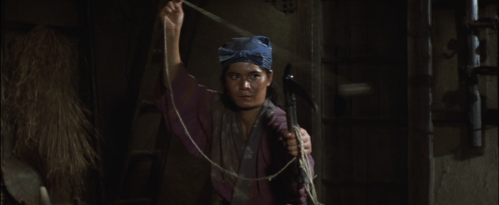 Screenshot of a young Japanese woman in period dress within a house, in which she wields a chain weapon