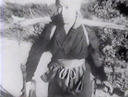 Old image of a Japanese peasant girl on a country road, carrying two buckets on a long pole across her shoulders.