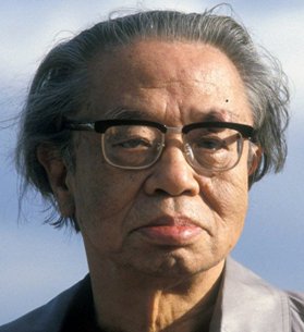 Portrait of an elderly Japanese man with glasses, grey hair and a dour expression 