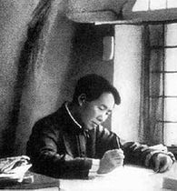 A still young Mao Tse-tung is seated at a desk, writing, with light entering the room from the window beside him