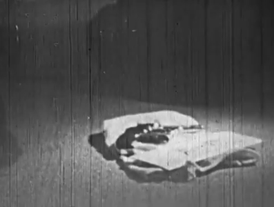 A photo of a pistol lying on a piece of cloth on the ground
