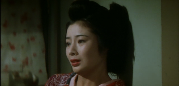 Head and shoulders shot of a young Japanese woman in traditional dress leaning against a wall, looking distraught