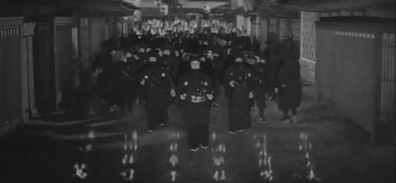The Japanese protagonist and his gang, all dressed as ninjas, march through the town, as the film's credits can be seen rising at the bottom of the screen