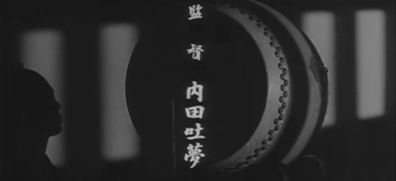 A Japanese man in silhouette beats a drum in the foreground as the credit "Directed by Uchida Tomu" appears on the screen