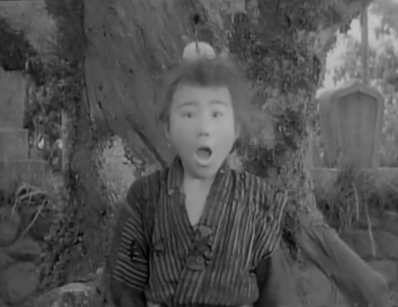 The boy from the first picture with the boar, with his back to the tree, has a look of amazement on his face as the arrow appears in the piece of fruit upon his head